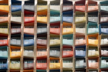 Renkli açılı balkonlu, ritmik ve simetrik desenli parlak, modern apartman dairesi. Kentsel, mimari veya soyut tasarım temaları için ideal
