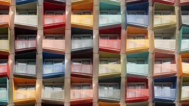 Renkli açılı balkonlu, ritmik ve simetrik desenli parlak, modern apartman dairesi. Kentsel, mimari veya soyut tasarım temaları için ideal