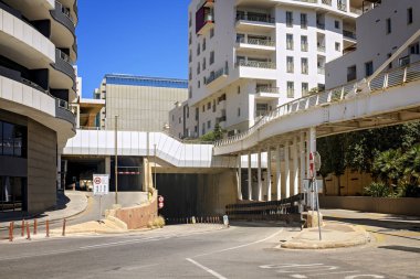 Tünel girişi, trafik işaretleri ve işaretleriyle yol ayrımları, metal destekli yüksek yaya köprüsü ve çağdaş şehir binaları bulunan modern şehir kavşağı..