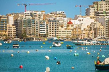 Çağdaş bir Akdeniz şehri ve rıhtımının manzarası demirli tekneler, feribotlar, renkli şamandıralar ve arkasında kırmızı kubbe olan bir Katolik kilisesi. Seyahat, turizm ve şehir yaşam tarzı kavramı.