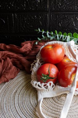 Doğal iplikten yapılmış sürdürülebilir bir alışveriş poşetinde taze domatesler. Ekoloji kavramı.