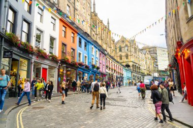 Edinburgh, İskoçya, Uk - 18 Ağustos 2023: Turistler, bir yaz günü Victoria Caddesi boyunca renkli evleriyle turistik yerleri geziyorlar.