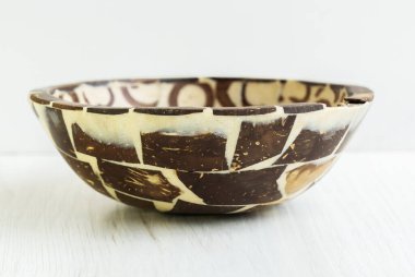 Beyaz arka planda reçine ve tarçın parçacıklarından yapılmış el yapımı boş bir kasenin önü. Yatay stüdyo çekimi.