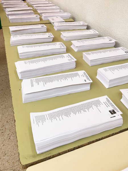 Госпиталь Льобрегат, Барселона, Испания - 9 июня 2024 года: стопки бюллетеней для голосования различных политических партий на избирательном участке в день выборов в Европейский парламент.