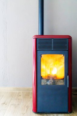 Pelet sobası yanıyor. Kış konsepti, soğuk hava ve ısıtma. Dikey.
