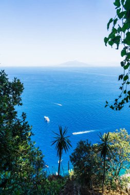 Ufukta Vezüv volkanı olan yatlar, İtalya 'nın Capri kıyısında yelken açıyor. Dikey.