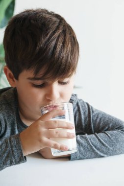 8 yaşındaki İspanyol çocuk kahvaltıda bir bardak süt yiyor. Sağlıklı yeme kavramı.