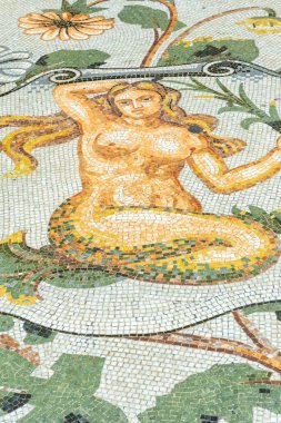 Eski mozaik zemin Napoli, İtalya 'da çiçek desenleriyle çevrili bir deniz kızını canlandırıyor.