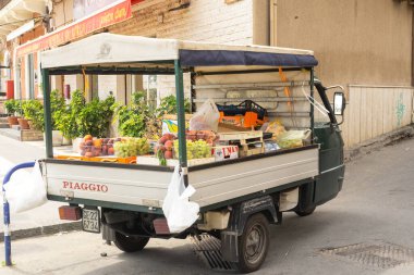 Sicilya, İtalya - 17 Ağustos 2024: Piaggio Goril parkında şeftali, üzüm ve diğer taze ürünleri şehir pazarında satıyor