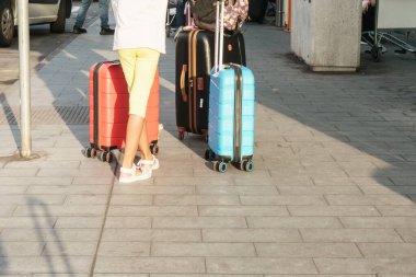 Sicilya, İtalya - 17 Ağustos 2024: Turistler bagajlarıyla birlikte Catania havaalanı terminalinin önündeki kaldırımda duruyorlar.