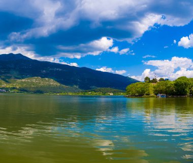 Suda yansıması olan Yunan adası manzarası