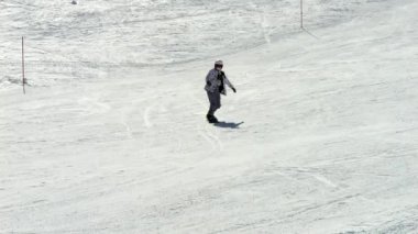 Şık bir bayan snowboardcu, karlı bir yamaçtan kayarak kayar. Yavaş çekim 4K her hareketi zarafet ve hassasiyetle yakalar, dinamik ve sinematik bir his yaratır..