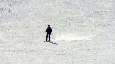 Siyah kayak kıyafetli bir bayan sporcu, karlı bir yamacı düzgün bir şekilde oyuyor. Yavaş çekim 4K her hareketinde onun hassasiyetini, dengesini ve zarafetini yakalar..