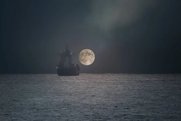 stock image Commercial ship on the horizon in a full moon night