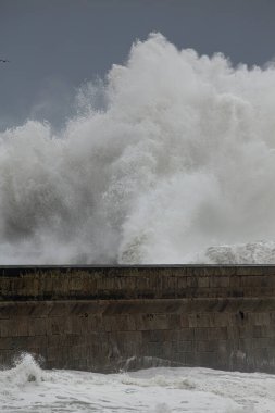 Büyük fırtınalı deniz dalgası sıçraması. Kuzey Portekiz kıyılarından rıhtım.