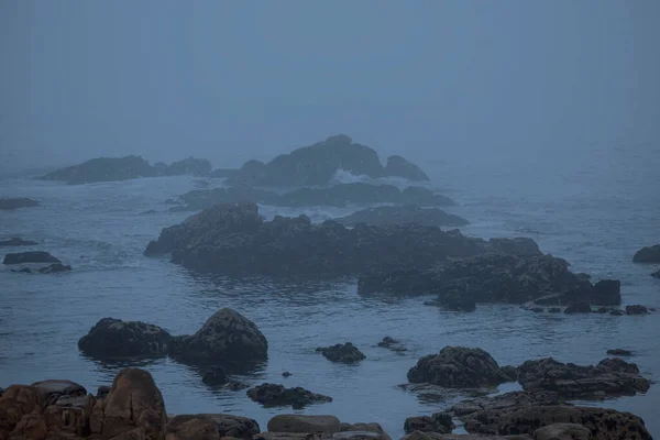 stock image Foggy rocky coast at dusk or night