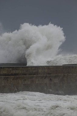 Büyük fırtınalı deniz dalgası sıçraması. Kuzey Portekiz kıyılarından rıhtım.