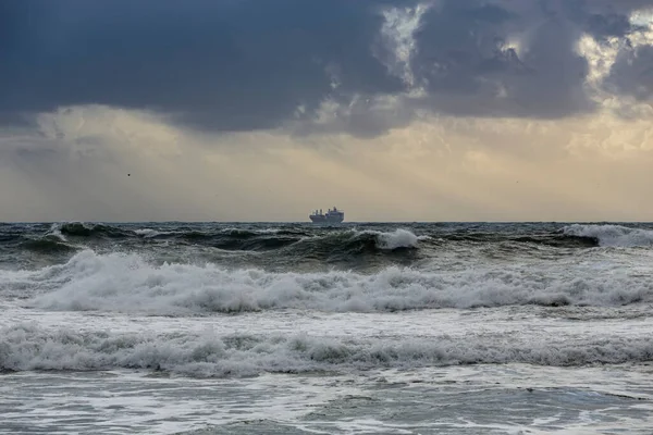 夕阳西下的暴风雨海景 看到地平线上有一艘船 — 图库照片