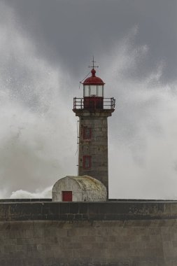 Eski deniz fenerinde büyük dalga sıçraması. Kuzey Portekiz kıyıları.