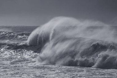 Kış deniz manzarası ön planda büyük bir fırtına dalgası görüyor. Kuzey Portekiz kıyıları. Kullanılan kızılötesi filtre.