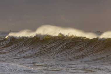 Gün batımında rüzgâr spreyiyle hafif fırtınalı dalgalar..