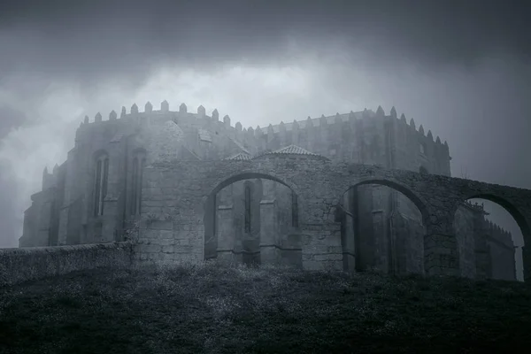 Mysterious medieval granite monastery in a foggy and overcast evening. Vila do Conde, Portugal. Converted black and white and toned blue.