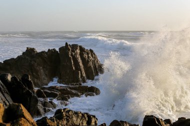 Portekiz 'in kuzeyindeki Labruge, S. Paio' nun kayalıkları, gün batımında dalgalı bir deniz günü..