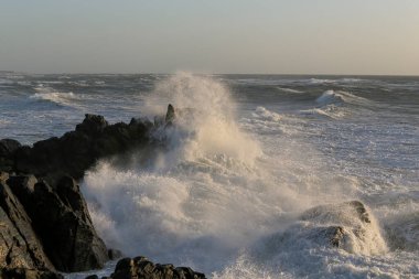 Portekiz 'in kuzeyindeki Labruge, S. Paio' nun kayalıkları, gün batımında dalgalı bir deniz günü..