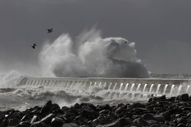 Portekiz 'in kuzeyinde, Douro Nehri' nin ağzındaki iskele ve fenerde fırtına var.