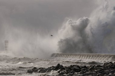 Portekiz 'in kuzeyinde, Douro Nehri' nin ağzındaki iskele ve fenerde fırtına var.