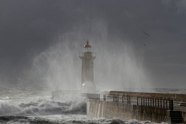 Douro nehrinin ağzındaki deniz dalgalarından püskürtme ve nem. Eski deniz feneri ve rıhtım.