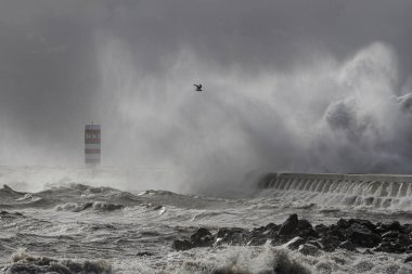 Portekiz 'in kuzeyinde, Douro Nehri' nin ağzındaki iskele ve fenerde fırtına var.