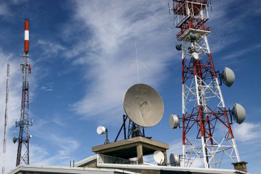 Dağ iletişim kulelerinin tepesi kırmızı ve beyaz ve uydu antenleri kapalı.