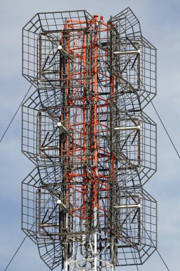 Bulutlu mavi gökyüzüne karşı eski kırmızı ve beyaz iletişim anteni