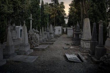 Gün batımında eski Avrupa mezarlığı ön planda ürkütücü bir açık mezar görüyor