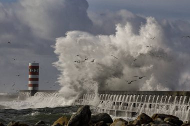 Büyük fırtınalı denizde dalga sıçrama. Douro nehir ağzı north pier ve işaret, Porto, Portekiz.