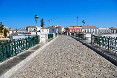 tourists on gilao river bridge and old town 14 September 2024 Tavira Portugal clipart