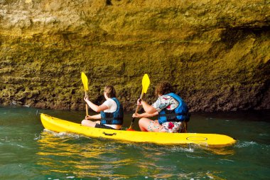 Kanocular kıyı boyunca kürek çeker, Algarve kaya oluşumu Portekiz 'in Porches kasabasında bulunan eşsiz ve çarpıcı bir doğa harikasıdır.
