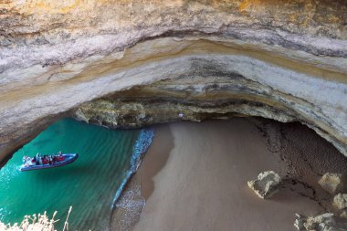 Benagil mağarasının içinde turistlerle dolu bir tekne kayaların aşınmasıyla oluşmuş karakteristik açılışıyla ünlüdür. 17 Sep 2024 Lagoa Portekiz