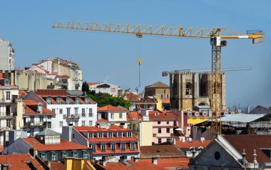 Lizbon Katedrali, aynı zamanda S de Lisboa olarak da bilinir, çevresindeki bir şehir alanı ve arka planında bir inşaat vinci vardır.