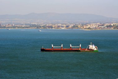 Lizbon, Portekiz 'in panoramik manzarası, ön planda Tagus Nehri ve Lizbon Portekiz' i geçen bir kargo gemisi.