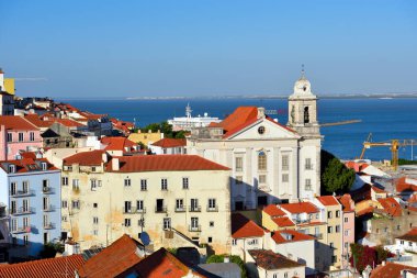 Lizbon, Portekiz 'in Alfama ilçesinin panoramik manzarası, Igreja de Santo Estvo (St. Stephen Kilisesi) ve Tagus Nehri (26 Mayıs 2025 Lizbon)