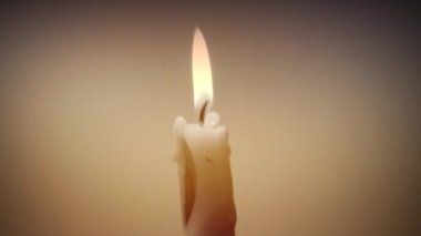 Attributes of religion and holidays. A candle burns on a yellow background.