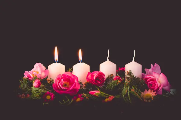 second burning advent candle on decorated rose flower pink advent wreath