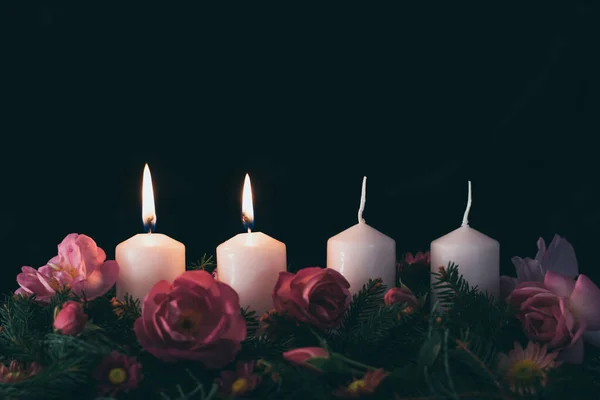 点缀玫瑰粉红花环上的第二支燃点蜡烛 — 图库照片