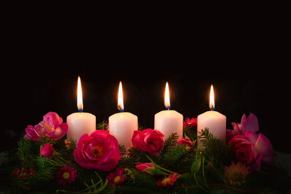 点缀玫瑰粉红花环上的第四支蜡烛 — 图库照片