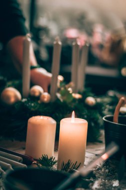 Noel süsleri, yanan mumlar ve geleneksel Noel doğal çelengi yapmak için hazırlanmış yeşil çam köknarı.