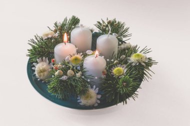 Yeşil köknar ve çiçeklerle süslenmiş 4 beyaz dini kristian çelengi.