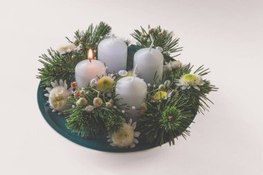 Yeşil köknar ve çiçeklerle süslenmiş 4 beyaz dini kristian çelengi.