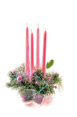 Yeşil köknar ve takılarla süslenmiş geleneksel çelenk şeklinde 4 adet pembe mum. 